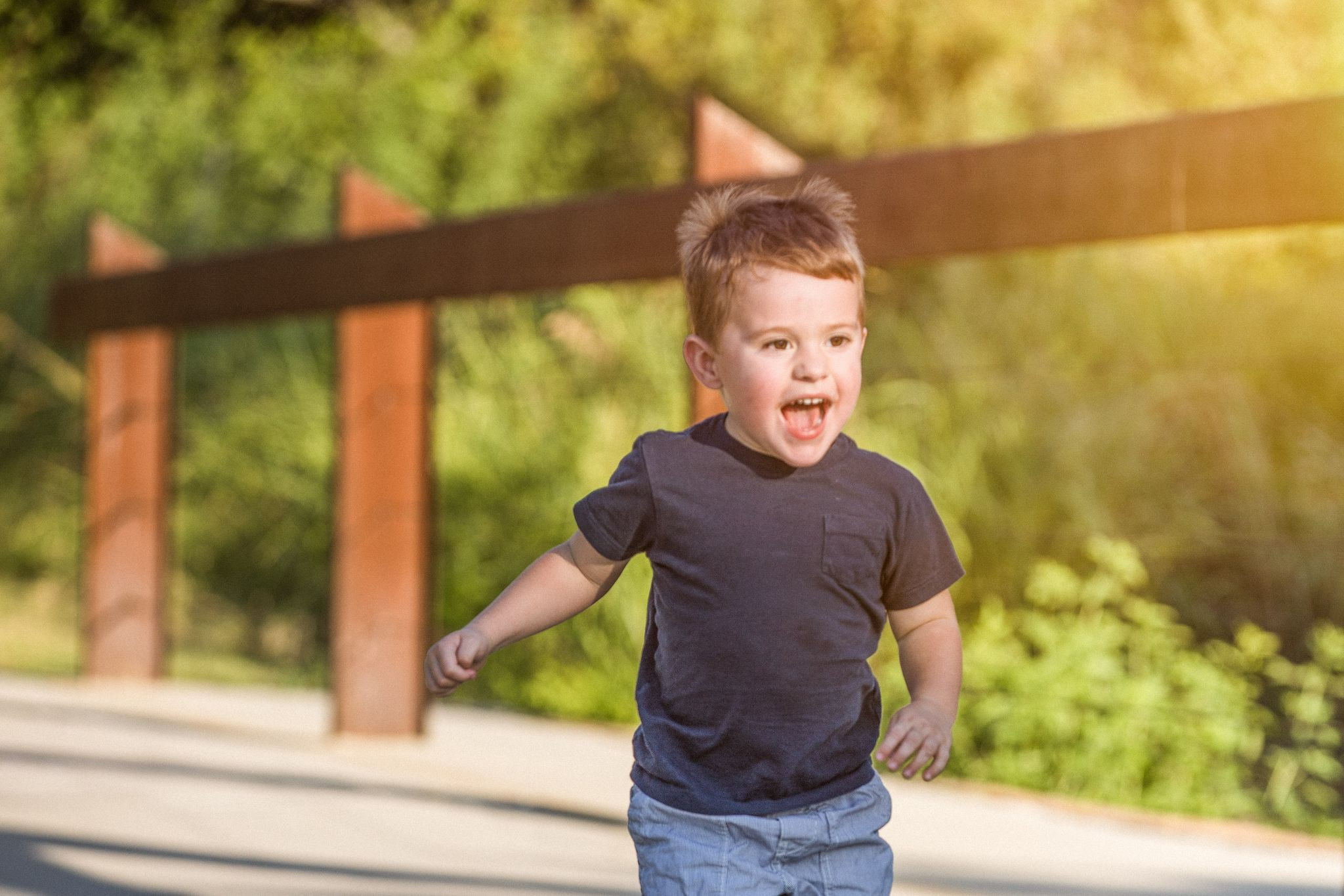 A young boy smiling and running.